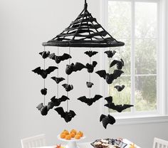 a table topped with a cake and bats hanging from the ceiling