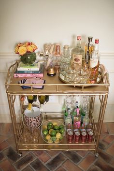 a gold bar cart filled with bottles and glasses