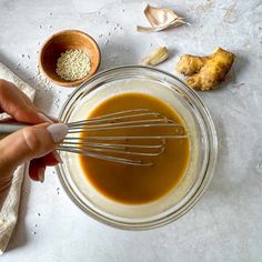 someone is whisking ingredients in a glass bowl