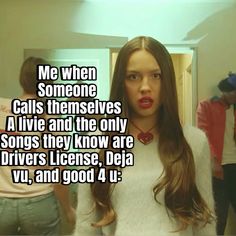 a woman with long brown hair standing in front of a mirror and looking at the camera