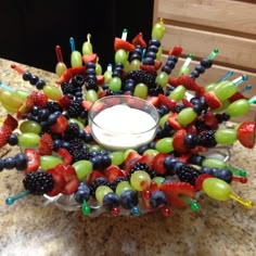 a bowl filled with lots of fruit on top of a counter