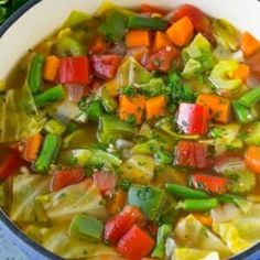 a bowl filled with soup and vegetables on top of a table