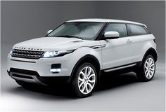 the white range rover is parked in an empty room with grey walls and flooring