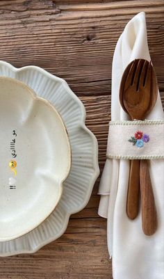 a white plate with a wooden spoon and fork on it next to a paper napkin