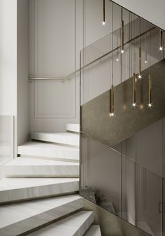 a staircase with lights hanging from it and some white steps in front of the stairs