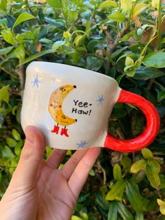 a hand holding a coffee cup with the words yee - haw on it