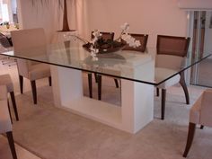 a glass dining table with chairs around it