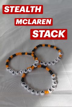 two bracelets with letters on them are sitting on a white sheet that says stealth mclaren stack