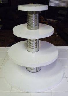 three tiered white cake stand sitting on top of a tiled floor