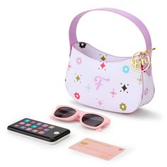 a pink purse with sunglasses, cell phone and card holder sitting next to it on a white surface