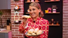 a woman holding a plate with donuts on it