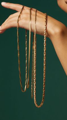 a woman's hand holding several different types of bracelets