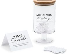 a glass jar with some napkins on it and a card in front of it