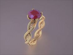 a gold ring with a pink stone in the center and an intricate band around it