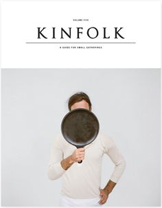 a man holding a frying pan over his face with the words kinfolk on it