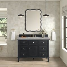 a bathroom with a sink, mirror and two lights hanging from the ceiling above it