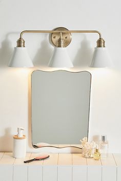 a bathroom vanity with three lights and a mirror