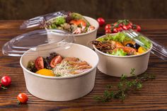 three plastic containers with different types of food in them on a wooden table next to tomatoes, lettuce and other vegetables