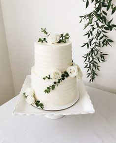 a wedding cake with white flowers and greenery