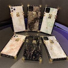 four cell phones are sitting on top of each other with gold and black speckles