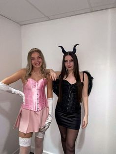 two women dressed in costumes posing for the camera