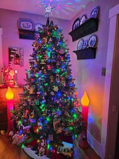 a brightly lit christmas tree in the corner of a room with other decorations on it