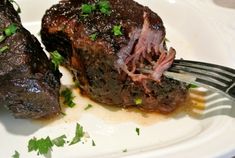 two pieces of steak on a plate with a fork