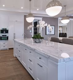 a large kitchen with white cabinets and marble counter tops is featured on the instagram page