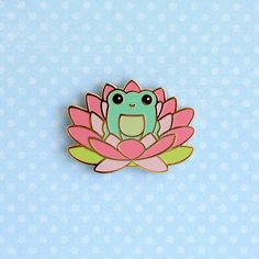 a green and pink frog sitting on top of a flower with its eyes closed,