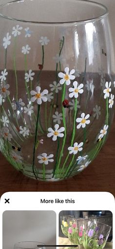 a glass bowl with flowers painted on it and the bottom half is filled with water