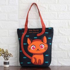 an orange cat is sitting on top of a black tote bag with fish in the background