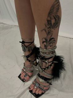 a woman's legs with tattoos and feathers on them