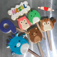 there are many decorated cookies on top of the cake popss that have animals on them