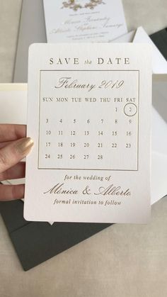 a person holding up a save the date card