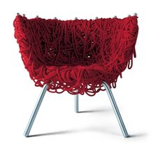 a chair made out of red yarn with metal legs