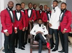 a group of men in tuxedos posing for a photo with one man sitting on a chair