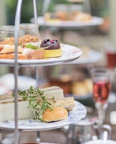 three tiered trays filled with different types of desserts and pastries on top of each other