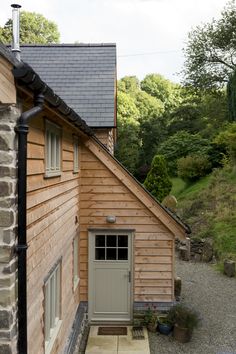 a small wooden building sitting on top of a lush green hillside