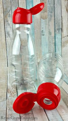 two plastic water bottles sitting on top of a wooden table next to eachother