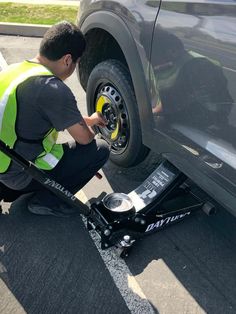 a man working on the front wheel of a truck