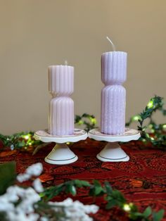 two white candles sitting on top of each other