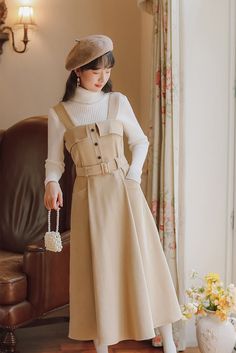 Midi pinafore dress with thick shoulder straps, button front, belted waist, side pockets and pleated skirt. Concealed back zipper. S: 33" chest, 27" waist, 42" lengthM: 34.5" chest, 28.5" waist, 42" lengthL: 36" chest, 30" waist, 42.5" lengthXL: 37.5" chest, 31.5" waist, 42.5" length Workwear Midi Dresses With Adjustable Straps, Midi Length Dresses With Adjustable Straps For Work, Spring Pinafore Dress With Pockets For Work, Spring Workwear Pinafore Dress With Pockets, Spring Workwear Pinafore Dress With Buttons, Japanese Winter Fashion, Dresses For Autumn, Preppy Style Women, Midi Pinafore Dress