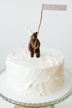 a white cake with a small brown bear on top