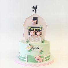 there is a cake that has pigs on it and a barn in the back ground