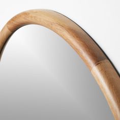 a mirror that is made out of wood and has a curved handle on the side