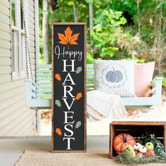 a sign that says happy harvest on it next to some pumpkins and other decorations