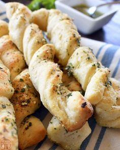 several pieces of bread with herbs on them sitting on a blue and white striped napkin