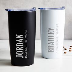 two black and white tumblers sitting next to each other on top of a table