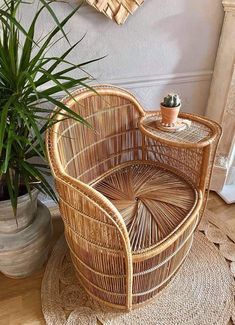 a wicker chair sitting on top of a rug next to a potted plant