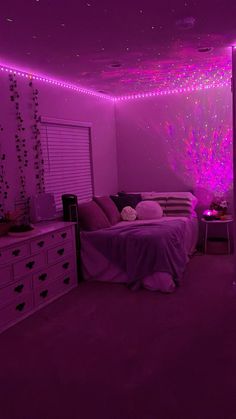 a bedroom with purple lighting and bed in the middle is lit up by pink lights